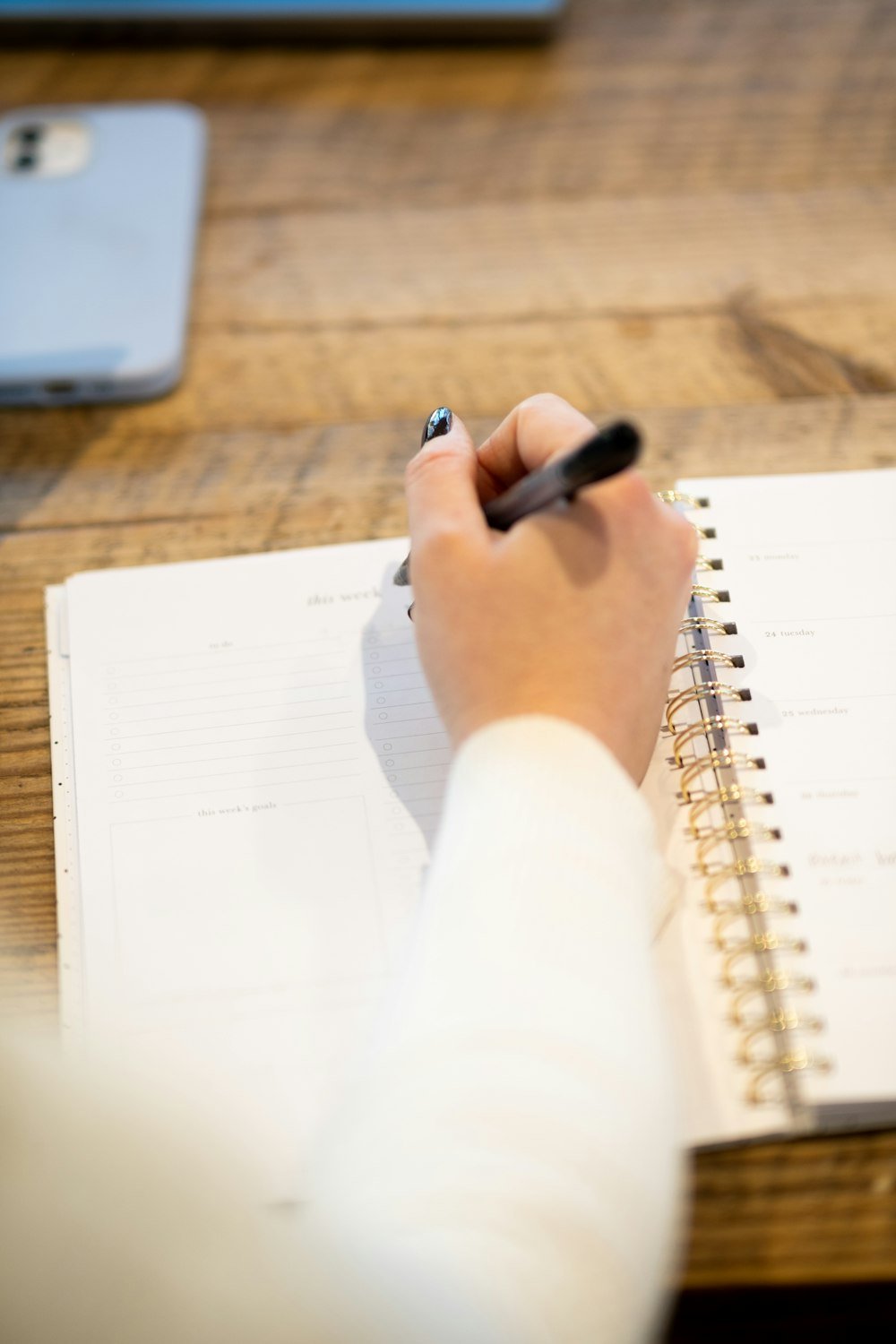 Person macht sich Notizen an einem Tisch